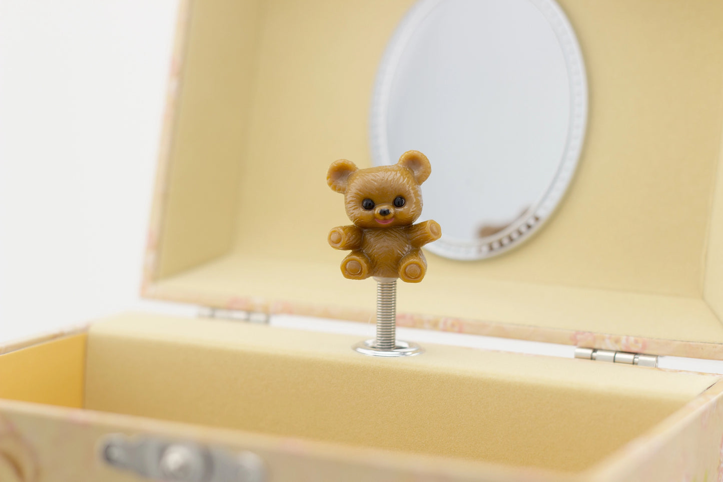 Yellow jewelry box with a teddy bear-shaped earring on a white background
