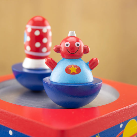 Colorful toy with a character on a red base against a beige background